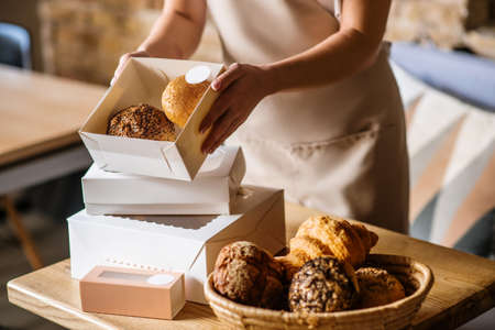 Female caring hands holding small box of buns