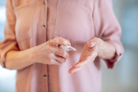 Close up of a woman spraying perfume on her wristの写真素材