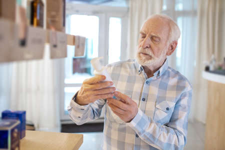 Mature man choosing a new fragrance in a beauty shopの写真素材