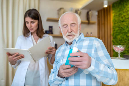 Mature man choosing a body lotion in a beauty shopの写真素材