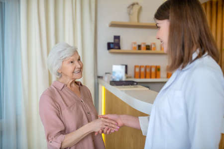 Mature woman meeting a cosmetologist in a beauty centerの写真素材