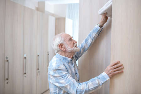 Gray-haired mature man in a changing room in spa centerの写真素材