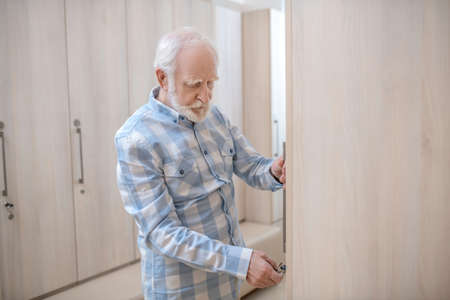 Gray-haired mature man in a changing room in spa center