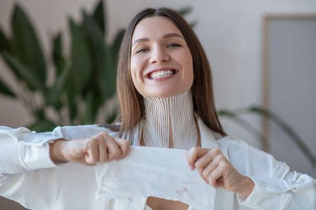 Cute young woman stretching the tape before applying itの写真素材