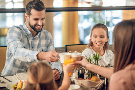 Happy family having breakfast together and looking excitedの写真素材