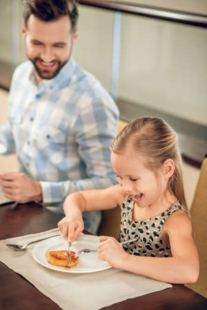 Young father having a breakfast with his daughterの写真素材
