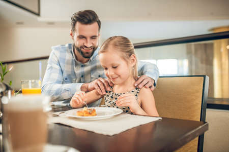 Young father having a breakfast with his daughterの写真素材