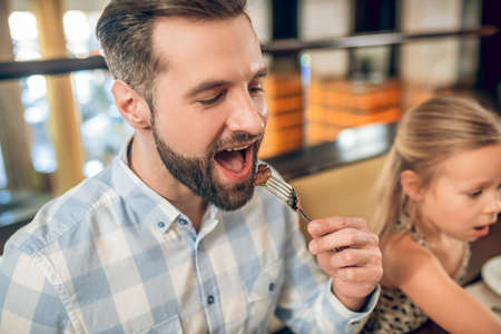 Bearded young man having breakfast with his familyの写真素材