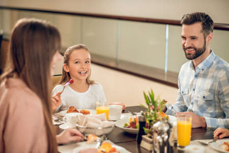 Smiling family sitting at the table and looking happyの写真素材