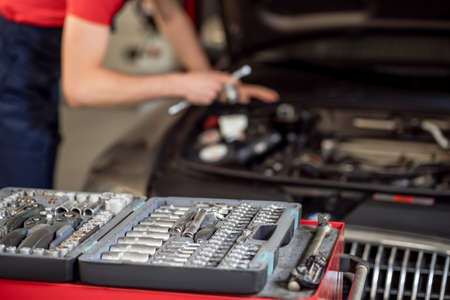 Case with parts and auto mechanic near car hoodの写真素材