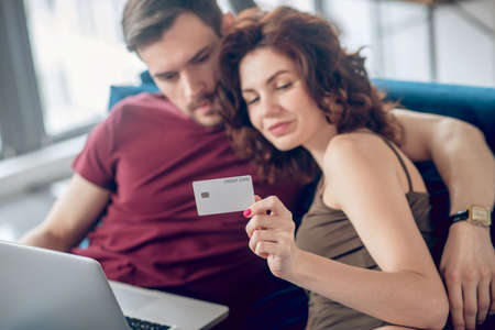 Young cute couple planning to buy something online