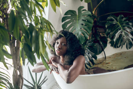 Pretty african american woman relaxing in a bath