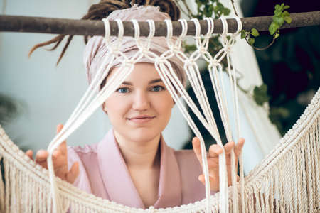 Cute young woman waeving and looking positiveの写真素材