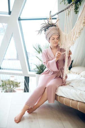 Young woman spending time at home busy with her macrame