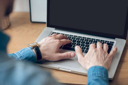 Close up picture of mans hands typing on a laptopの写真素材