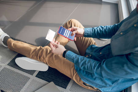 Man holding a smartphone and making online payment via applicationの写真素材