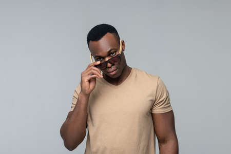 Man in sunglasses touching them with his handの写真素材