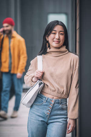 Young woman feeling bored while her boyfriedns talking on the phone
