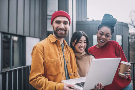 Three friends watching something online and feeling interestedの写真素材