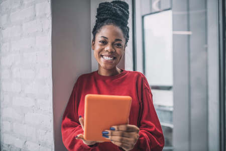 African american cute woman with a tablet looking excitedの写真素材