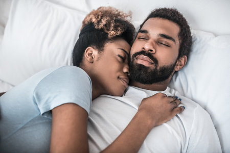 Dark-skinned young husband and wife hugging each other.の写真素材