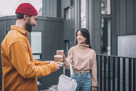 Young man and woman meeting to have a cup of coffee togetherの写真素材