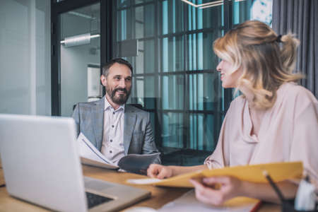 Bearded man and blonde woman studying papers