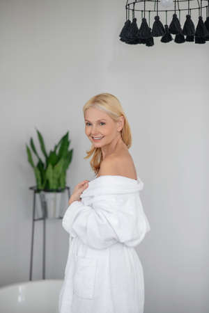 Pretty woman in a white robe with naked shouldersの写真素材
