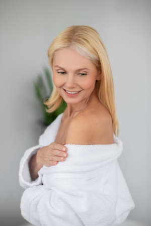 A beautiful woman in a white bath robe looking goodの写真素材