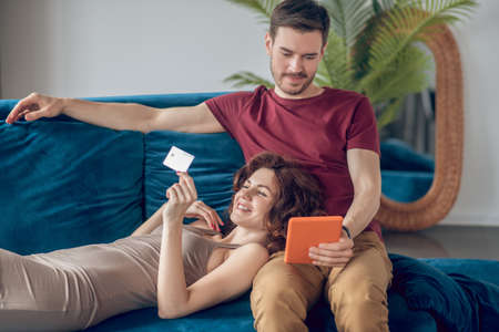 A man and a woman sitting on the sofa with a laptopの写真素材