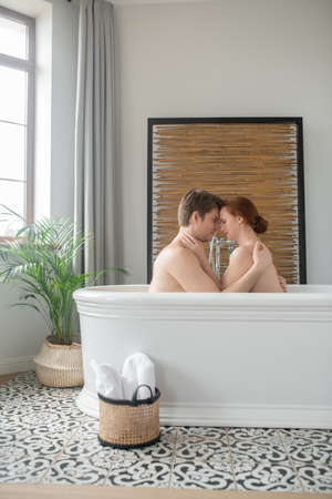 A man and a woman having a bath together, kissing and huggingの写真素材