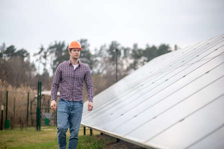 Concentrated man in helmet near engineering structure
