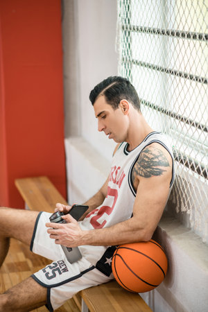Young man with tatoo resting after a workout