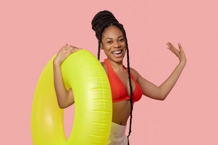 Smiling african american woman holding a yellow tubeの写真素材