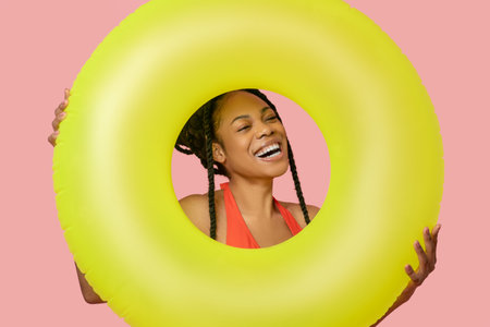 Smiling african american woman holding a yellow tube and having fun