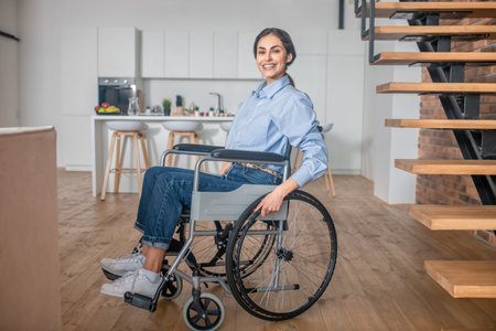 Positive handicapped young woman at home and looking happyの写真素材