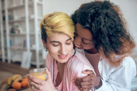 African American woman touching face of caucasian girlfriendの写真素材