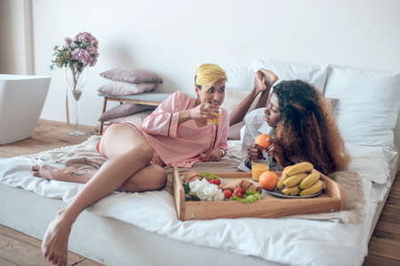 Couple female relaxed chatting on bedの写真素材