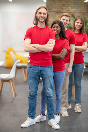 Two guys and girls volunteers standing one by one