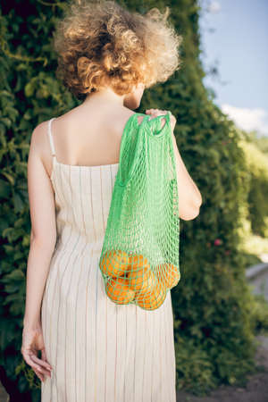 Young vegan going home from the shop with fruitsの写真素材