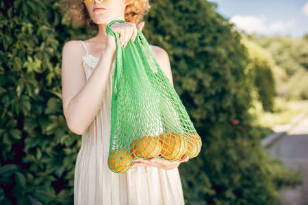 Young woman i holding a bag with fruits in her handsの写真素材