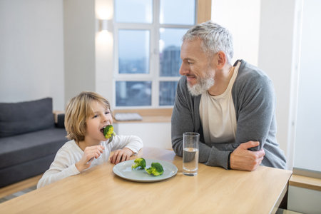 Mature man and his son having breakfast togetherの写真素材