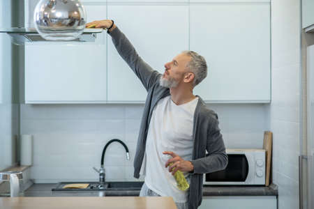 Man in homewear doing housework and looking busyの写真素材