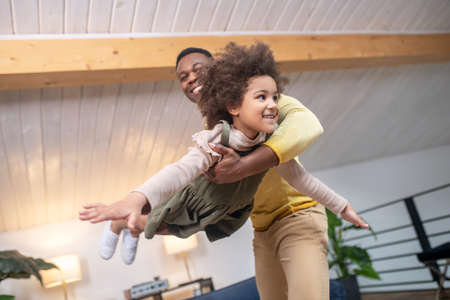 Dad holding his daughter in air