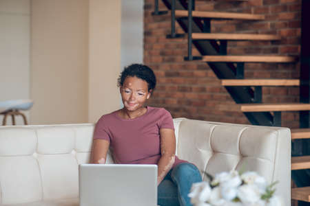 Cute young woman working from home and looking involvedの写真素材