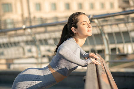 Fit girl in grey sportswear doing push ups and looking determined
