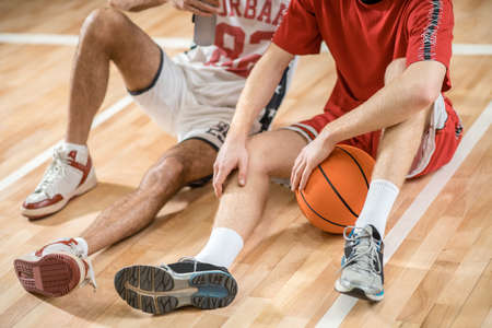 Men in sportswear resting after the basketball game and talkingの写真素材