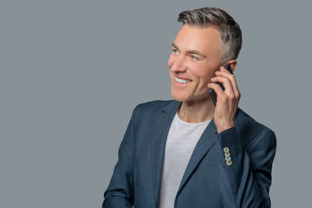 Man talking on smartphone in good moodの写真素材