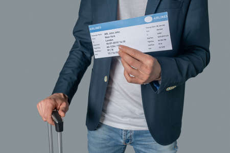 Hand of man in jacket showing ticket
