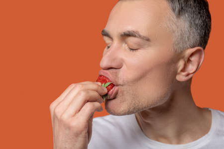Close-up of man eating fresh strawberries